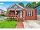 Charming red brick home featuring a welcoming front porch and manicured lawn at 50 Ormond Sw St, Atlanta, GA 30315