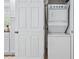 Neat laundry area with a stacked washer and dryer unit and a white door at 50 Ormond Sw St, Atlanta, GA 30315