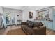 Living room with a brown sofa, light wood floors, and an exterior view from the glass paneled doors at 50 Ormond Sw St, Atlanta, GA 30315