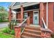 Inviting front porch featuring brick columns, a porch railing, and a stylish front door at 50 Ormond Sw St, Atlanta, GA 30315
