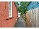 Narrow side yard showing a brick wall, a wooden fence, and a glimpse of the back garage at 50 Ormond Sw St, Atlanta, GA 30315