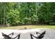 Beautiful backyard featuring a seating area with chairs, stone fire pit, and a tree-lined fence for added privacy at 6061 Meridian Nw Dr, Acworth, GA 30101