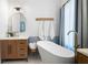 Bright bathroom featuring wood vanity, soaking tub, herringbone backsplash, and modern fixtures at 6061 Meridian Nw Dr, Acworth, GA 30101