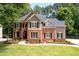 Attractive home featuring a brick facade, well-manicured lawn, professional landscaping, and a welcoming walkway to the entrance at 6061 Meridian Nw Dr, Acworth, GA 30101