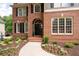 Elegant brick home with a grand arched entrance and beautifully landscaped flowerbeds at 6061 Meridian Nw Dr, Acworth, GA 30101