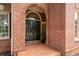 Inviting brick entryway with double doors, arched transom window, and manicured landscaping at 6061 Meridian Nw Dr, Acworth, GA 30101