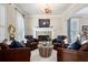 Inviting living room featuring a stone fireplace, hardwood floors, and leather armchairs at 6061 Meridian Nw Dr, Acworth, GA 30101