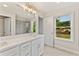 Bright bathroom featuring a double vanity, large mirror, and a doorway to the shower room at 101 Priestwood Ln, Acworth, GA 30102