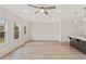 Spacious living room featuring light wood flooring, a ceiling fan, and natural light from windows at 101 Priestwood Ln, Acworth, GA 30102