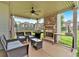 Cozy outdoor area with stone fireplace, grill, ceiling fan, and comfortable seating at 2239 Noelle Pl, Powder Springs, GA 30127