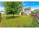 Spacious, grassy backyard features a home with solar panels, mature trees, and fenced perimeter at 2239 Noelle Pl, Powder Springs, GA 30127