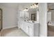 Bright bathroom features dual sinks, modern lighting, and ceramic tile floors at 2239 Noelle Pl, Powder Springs, GA 30127