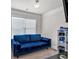 Comfortable seating area with a plush blue sofa, large window, and modern entertainment setup at 2239 Noelle Pl, Powder Springs, GA 30127