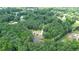 An aerial view showcasing a secluded home nestled in a private wooded lot with a pond at 871 Cowan Se Rd, Conyers, GA 30094