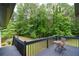 Back deck offers a serene view of treeline with a small table and chair at 871 Cowan Se Rd, Conyers, GA 30094
