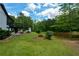 Backyard view featuring lush lawn, small pond, and ample trees at 871 Cowan Se Rd, Conyers, GA 30094