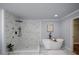 Luxurious bathroom featuring a walk-in shower with marble tiling and a standalone soaking tub at 871 Cowan Se Rd, Conyers, GA 30094