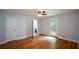 Sunlit bedroom features hardwood floors, ceiling fan, and access to a balcony at 871 Cowan Se Rd, Conyers, GA 30094