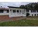 Charming single-story home featuring a covered front porch, white siding, black shutters, and well-maintained landscaping at 871 Cowan Se Rd, Conyers, GA 30094