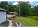 Exterior view featuring a large lawn, outbuilding, and outdoor cooking area at 871 Cowan Se Rd, Conyers, GA 30094