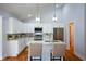 Beautiful kitchen features white cabinets, stainless appliances, and an island with seating and modern light fixtures at 871 Cowan Se Rd, Conyers, GA 30094