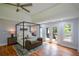 Main bedroom with hardwood floors, a ceiling fan, and access to a private balcony through French doors at 871 Cowan Se Rd, Conyers, GA 30094