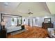 Spacious main bedroom with a tray ceiling, wood floors, a canopy bed, and an ensuite bathroom at 871 Cowan Se Rd, Conyers, GA 30094