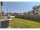 Wide view of fenced backyard showcasing green grass, patio and neighboring homes at 11910 Brightside Pkwy, Hampton, GA 30228