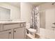 A bathroom with light cabinets, granite countertop, toilet and shower/tub combination with white floral shower curtain at 11910 Brightside Pkwy, Hampton, GA 30228