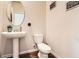Cozy half-bath with pedestal sink, toilet, and decorative wall art in neutral tones at 11910 Brightside Pkwy, Hampton, GA 30228