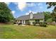 Expansive backyard featuring a well-maintained lawn, mature trees, and patio with outdoor furniture at 1865 Morgans Run Trl, Buford, GA 30519