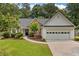 Charming single-story home featuring a well-manicured lawn and an attached two-car garage at 1865 Morgans Run Trl, Buford, GA 30519