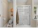 Bright bathroom featuring a glass-enclosed shower, tile flooring, and an adjacent toilet area at 1865 Morgans Run Trl, Buford, GA 30519