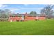 Classic red brick exterior showcasing the home's facade and surrounding green lawn at 2649 Lake Harbin Rd, Morrow, GA 30260