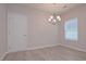 Charming dining room featuring light wood floors, a modern chandelier, and a window for natural light at 48 Beaver Pt, Villa Rica, GA 30180