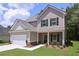 Charming two-story home showcasing a well-manicured lawn, a two-car garage, and a welcoming stone-accented entrance at 48 Beaver Pt, Villa Rica, GA 30180