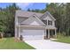 Charming two-story home showcasing a well-manicured lawn and a two-car garage surrounded by lush greenery at 48 Beaver Pt, Villa Rica, GA 30180