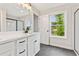 Bright bathroom featuring a dual vanity, walk-in shower with glass door, and large window at 105 Priestwood Ln, Acworth, GA 30102