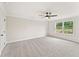 Spacious bedroom with plush carpet, a ceiling fan, and a large window allowing ample natural light at 105 Priestwood Ln, Acworth, GA 30102