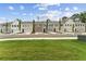 Street view of multiple new gray, brick, and white townhomes with attached garages and professionally maintained lawns at 105 Priestwood Ln, Acworth, GA 30102