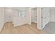 Upstairs hallway featuring wood floors, and doorways to a laundry room and a carpeted bedroom at 105 Priestwood Ln, Acworth, GA 30102