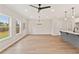 Open-concept living room and kitchen with hardwood floors, an island, a fan, and windows at 105 Priestwood Ln, Acworth, GA 30102
