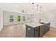 Open-concept kitchen and living room with hardwood floors, island, windows, and pendant lights at 105 Priestwood Ln, Acworth, GA 30102