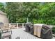 Back deck with gray deckboards has outdoor chairs, two barbeque grills, and string lights at 340 Chandler Ct, Sugar Hill, GA 30518