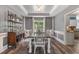 Dining room featuring dark wood floors, gray walls, wainscoting, and coffered ceiling, adjacent to kitchen at 340 Chandler Ct, Sugar Hill, GA 30518