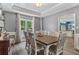 Dining room featuring dark wood floors, gray walls, wainscoting, coffered ceiling, and kitchen access at 340 Chandler Ct, Sugar Hill, GA 30518
