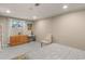 Bedroom with neutral walls, modern decor, wooden dresser, desk, and a window view at 6 Water View Dr, Stockbridge, GA 30281
