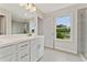 Bathroom with bright vanity, double sinks, and a view of the backyard from the window at 113 Priestwood Ln, Acworth, GA 30102