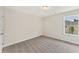 Spare bedroom with neutral carpet and a bright window that overlooks the side yard at 113 Priestwood Ln, Acworth, GA 30102