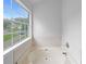 Bright white tiled bath and a window offering a serene view, perfect for relaxation at 2397 Charleston Ter, Decatur, GA 30034